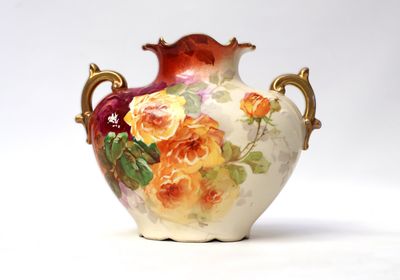a vase with a floral design on it sitting on a table