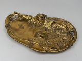 gold plate with a bird and flowers on it on a white surface