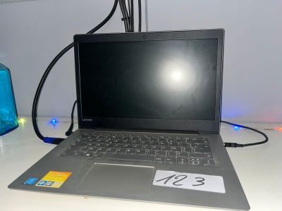 un ordinateur portable posé sur un bureau, avec une étiquette de prix dessus