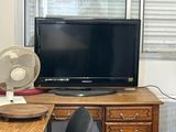 a desk with a fan and a television on top of it