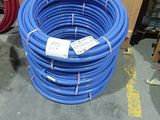 blue hoses are stacked on top of each other in a warehouse