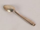 a silver spoon with a spoon handle on a white surface