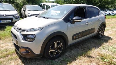 une petite voiture argentée garée dans l'herbe, près d'autres voitures