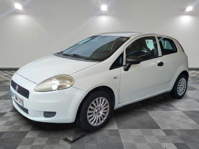 la petite voiture blanche est garée sur un carrelage à carreaux