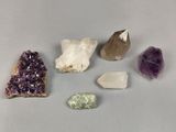 Plusieurs types de cristaux sont exposés sur une surface grise