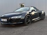 the audi sports car is parked in front of a building