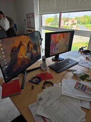 un bureau équipé de deux écrans et d'un clavier