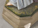 a figurine of a woman sitting on top of a suitcase