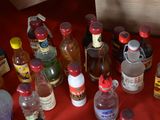 many bottles of alcohol on a red table cloth