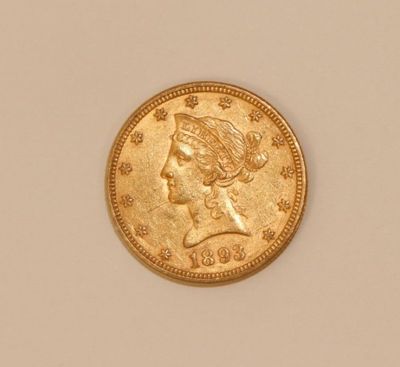 a close up of a gold coin with a woman ' s head on it