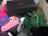 a pile of clothes and a laptop on a bed