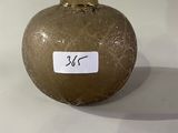 a brown vase with a sticker on it sitting on a table