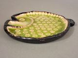 a black and green fish shaped dish on a table