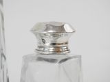a glass bottle with a silver lid and a silver stopper