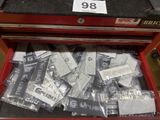 a red tool box filled with assorted metal items