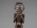 a wooden statue of a man with a hat on his head