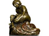 statue of a woman sitting on a rock holding a baby