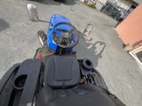 a blue motorcycle parked in a parking lot next to a building