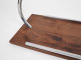 a metal object on a wooden stand on a white surface