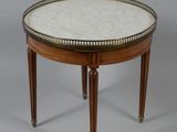 une table ronde avec un plateau en marbre et des pieds en bois
