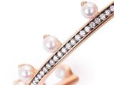 a close up of a ring with pearls and diamonds on a white background