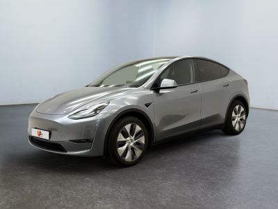 un SUV Tesla argenté garé dans une pièce au sol noir