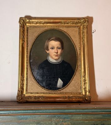 portrait d'un jeune garçon vêtu d'un pull noir et d'une chemise blanche à col