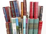 several books are stacked on top of each other on a white surface