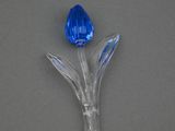 une fleur en verre bleu d'où sort une tige