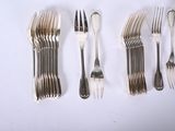 several forks and spoons are lined up on a white surface