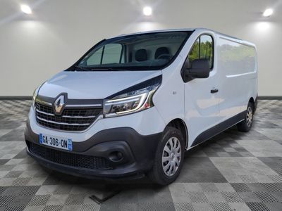 Une camionnette blanche est garée dans une pièce dont le sol est en damier.