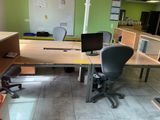 a desk with a computer and a chair in a room