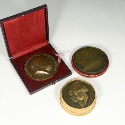deux pièces d'or dans une boîte rouge posée sur une surface blanche