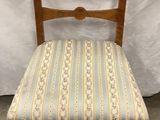 a wooden chair with a striped seat and back