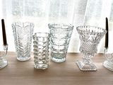 five glasses and a candle holder on a table