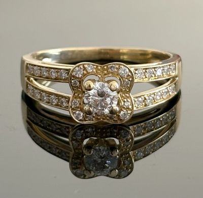 a close up of a diamond ring on a reflective surface