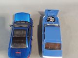 two toy cars sitting next to each other on a table