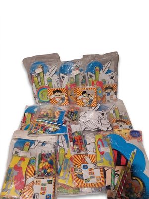 de nombreux sacs remplis de jouets posés sur un lit, sur fond blanc