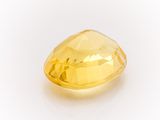 a close up of a yellow diamond on a white surface