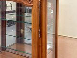 a wooden display case with glass shelves in a room