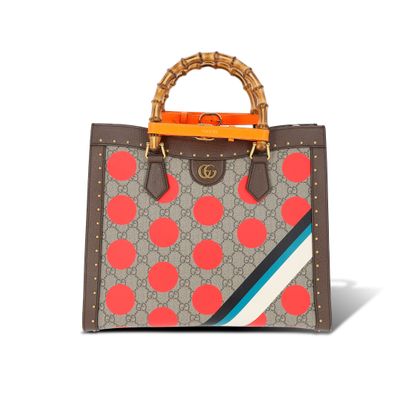 un sac à main marron et rouge avec une poignée en bambou sur fond blanc