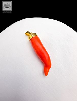 a red pepper sitting on top of a white egg