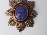 an image of a blue and gold medal with a crown on it