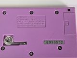 a purple electronic device that is on a table
