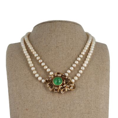 a close up of a necklace on a mannequin with pearls