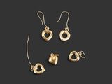 un ensemble composé de trois boucles d'oreilles en forme de cœur dorées et d'une paire de boucles d'oreilles
