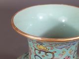 a blue vase with a gold rim sitting on a table