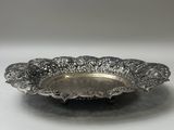 une assiette en argent posée sur une table, sur fond blanc