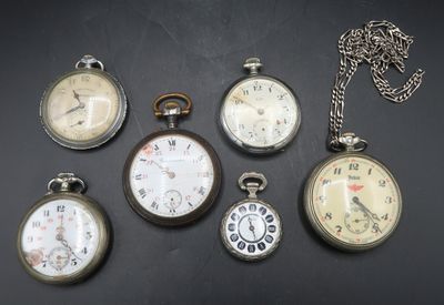 several different types of pocket watches are displayed on a black surface