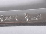 a close up of a silver spoon with writing on it